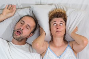 man snoring wife covers ears