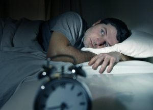 A man lying awake at night.