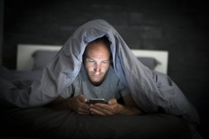 Man in bed with phone