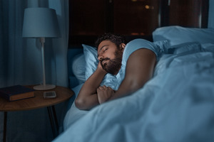 Bearded man with sleep apnea sleeping in bed