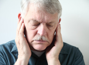 Concerned man with jaw pain and ringing in ears